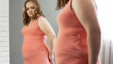 woman with a probleme to hide her belly fat in her tight dress